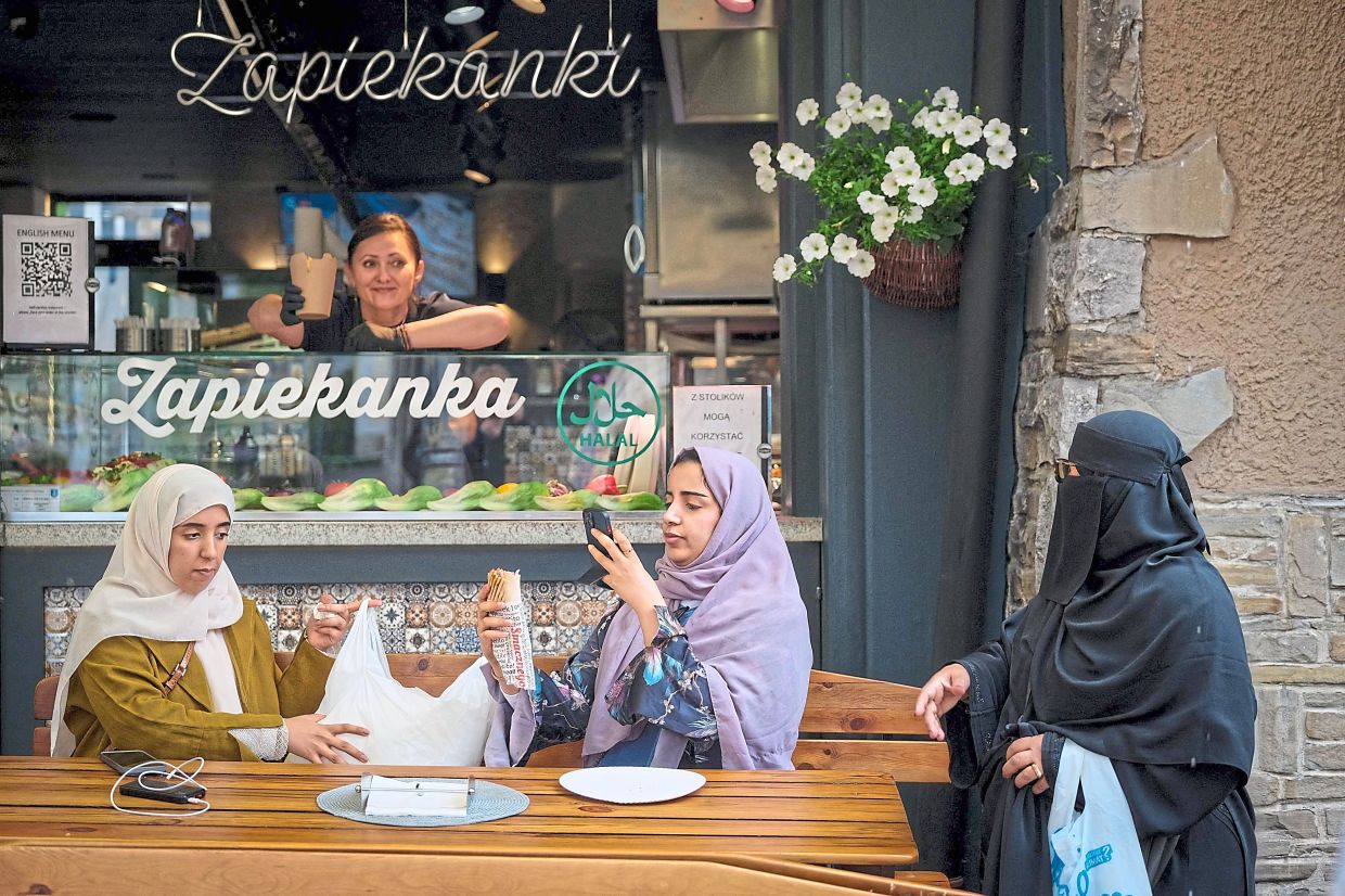 Tourists taking a picture of a kebab on Krupowki, the main pedestrian zone of Zakopane.