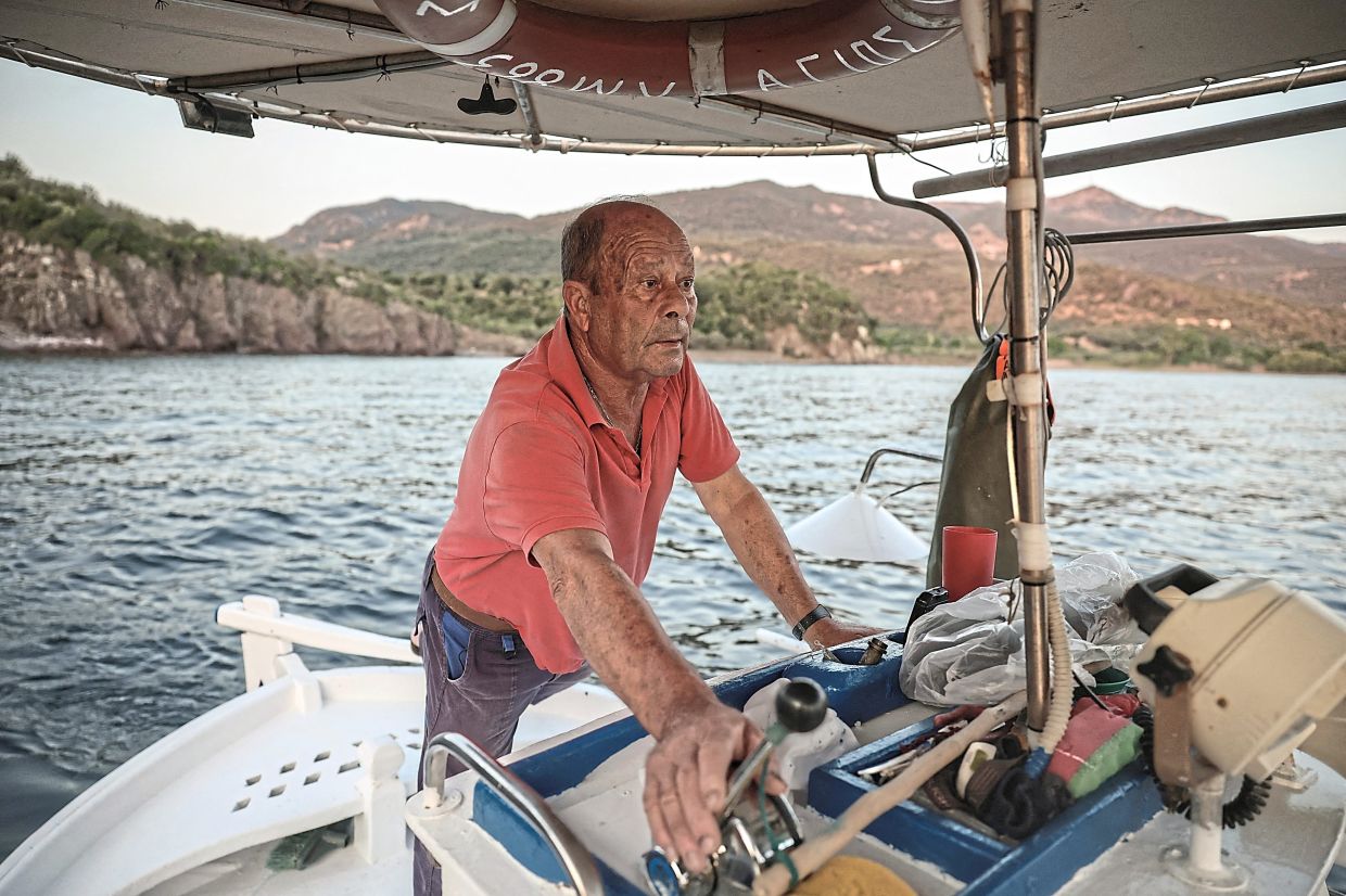Marmarinos driving his fishing boat near Skala Sykamias, off Lesbos island, Greece. — Reuters