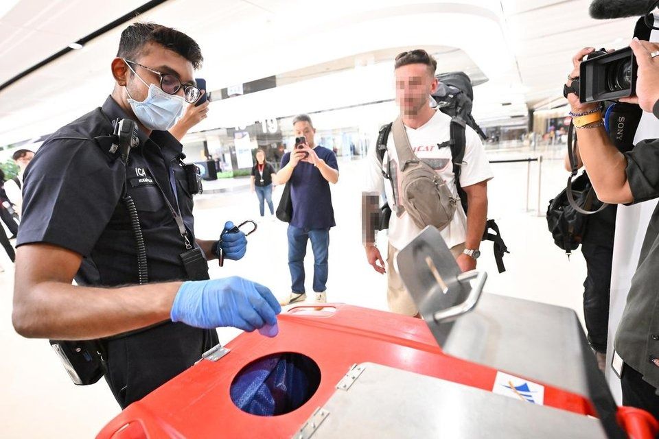 An ICA officer disposing of a vape after confiscating it from a traveller at Changi Airport Terminal 1 on Aug 22. - Photo: ST 