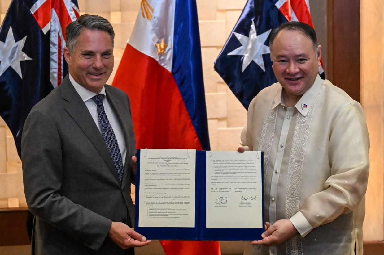 Philippine Defence Minister Gilberto Teodoro (right) and Australian Deputy Prime Minister and Minister for Defence Richard Marles (left) pose for a photo after signing the statement of intent for the enhanced defence cooperation in Makati, Metro Manila. -- Photo by Jam STA ROSA / AFP