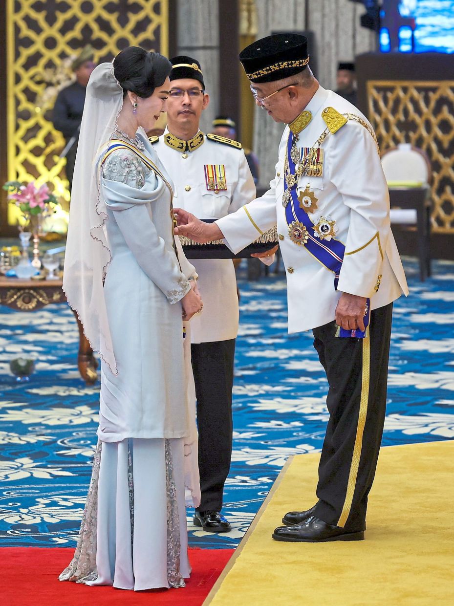Precious gift: Tun Mohd Ali (right) conferring the DPSM to Fan during the investiture ceremony in conjunction with his 76th birthday at Balai Istiadat Seri Negeri near Ayer Keroh. — Bernama