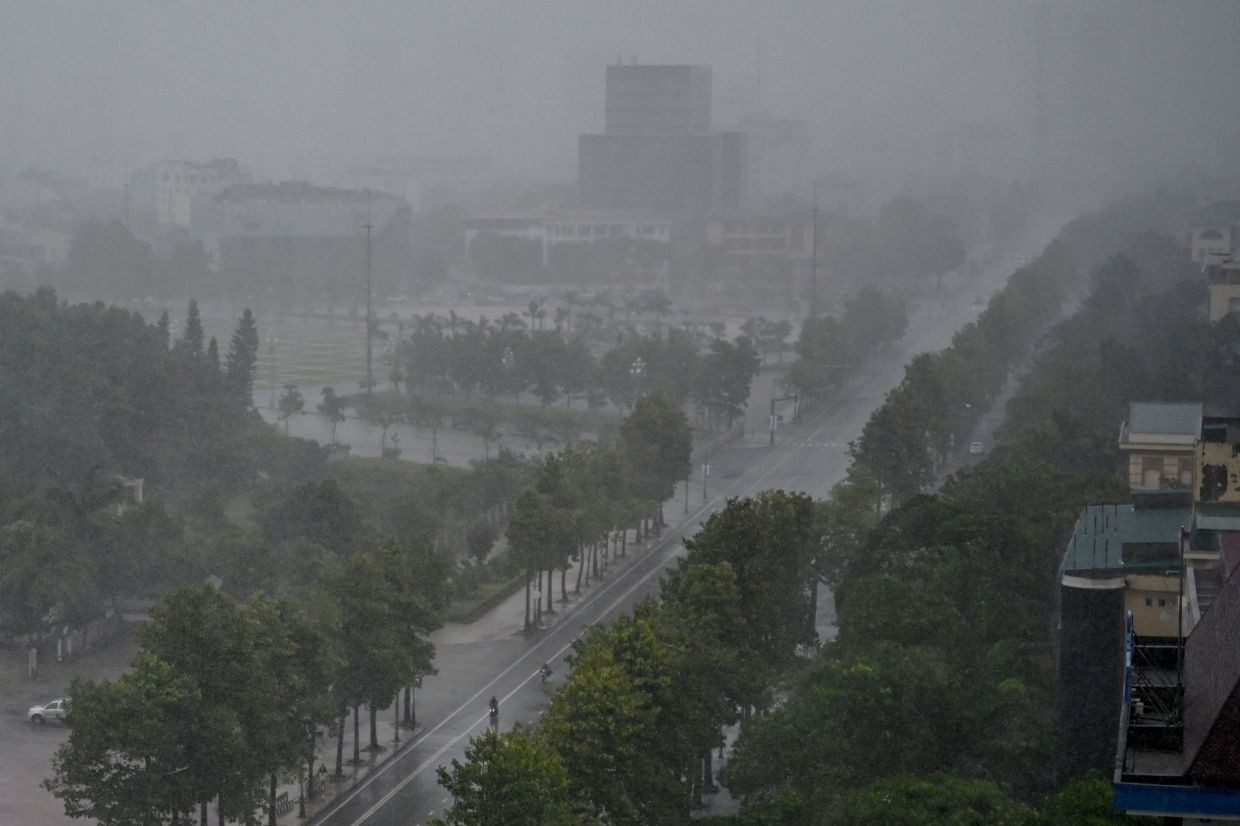 Rain falls above the buildings and a street in Vinh city, Nghe An province on Monday, August 25, 2025, before Typhoon Kajiki makes landfall in Vietnam. Tens of thousands of residents were being evacuated from coastal Vietnam on August 25, as Typhoon Kajiki barrelled towards landfall expected to lash the country's central belt with gales of around 160 kmh. The typhoon -- the fifth to affect Vietnam this year -- is currently at sea, roiling the Gulf of Tonkin with waves of up to 9.5 metres (31 feet). -- Photo by Nhac NGUYEN / AFP
