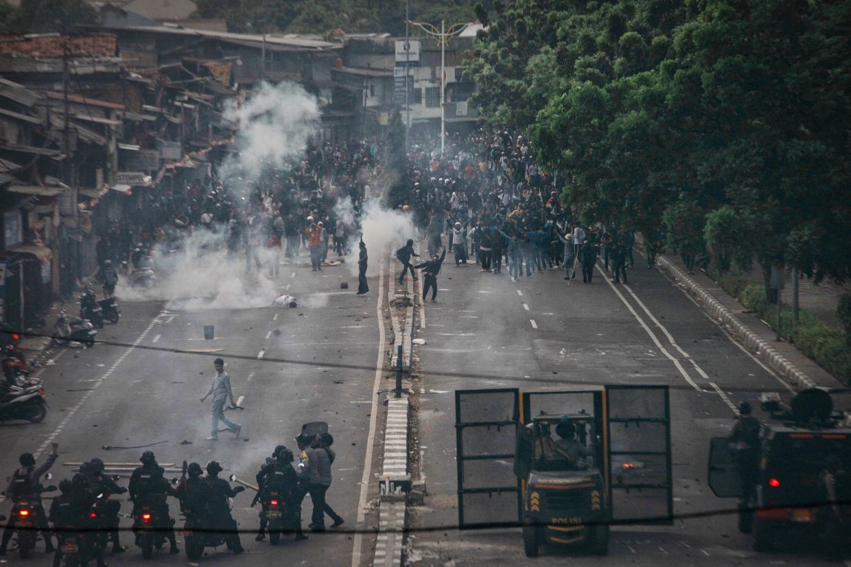 Protesters confront police officers during a demonstration demanding the dissolution of parliament on a street in Jakarta on Monday, August 25, 2025. -- Photo by Aditya IRAWAN / AFP