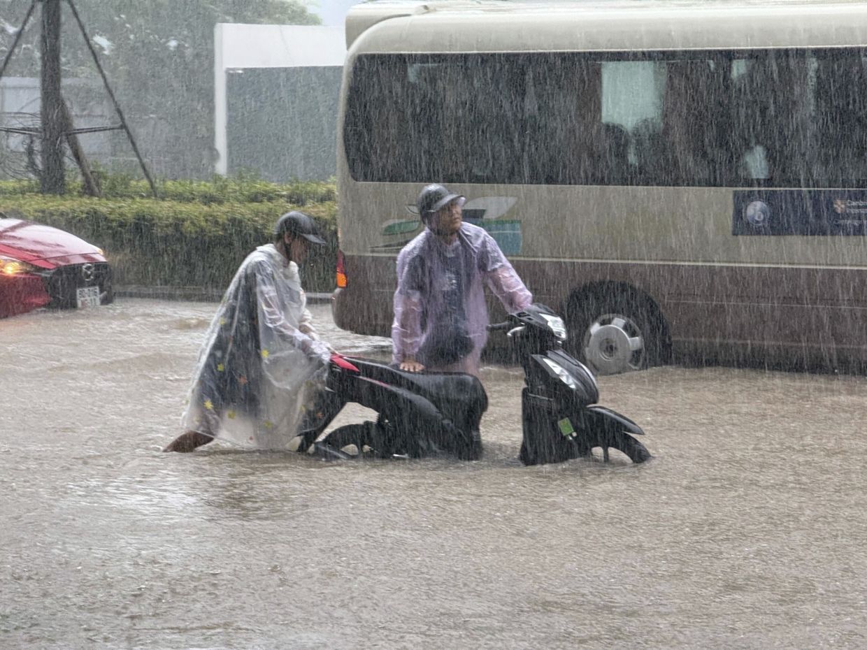 People pushing a motorbike through floods from heavy rains in Hanoi, after Typhoon Kajiki passed through Vietnam on Aug. 26, 2025. - AP 