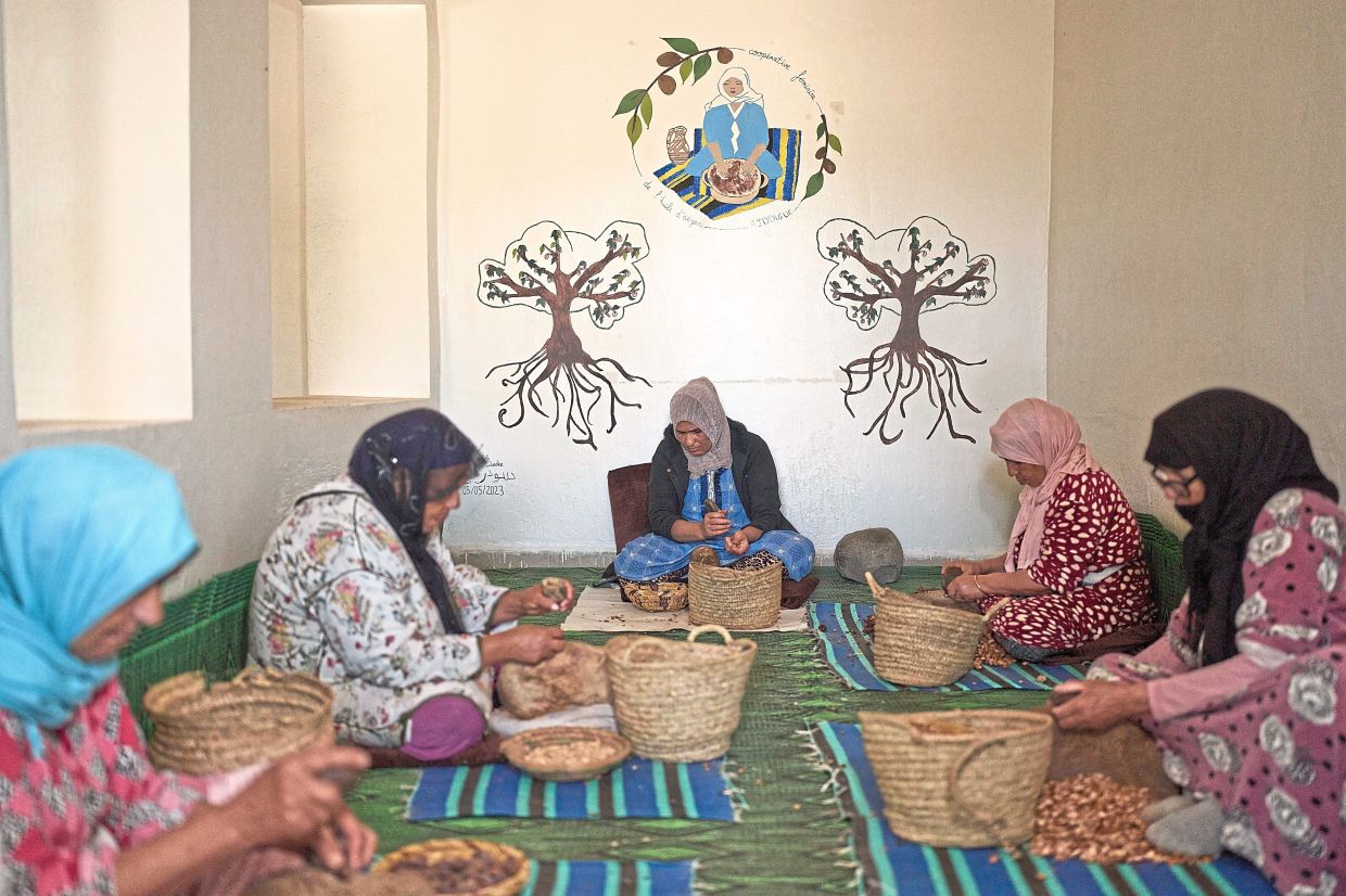 Women crack argan nuts at a cooperative that extracts and produces argan oil and products.