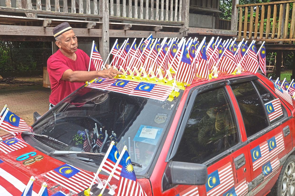 In Jerteh, Terengganu, gardener Wan Mustafa Wan Hasan bedecks his car with 68 flags to mark the nation’s years of independence.