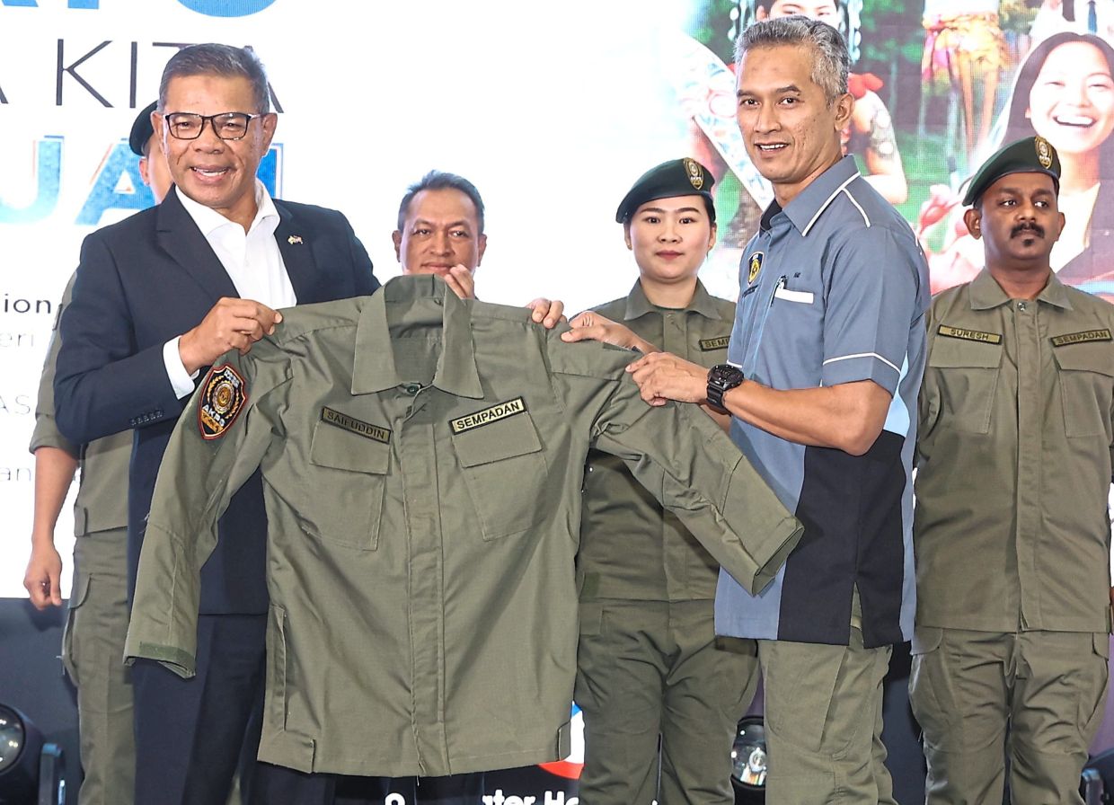 New look: Saifuddin Nasution (left) presenting the Borders Uniform to AKPS director-general Comm Datuk Seri Mohd Shuhaily Mohd Zain at the launching ceremony of ‘Benteng Persada‘ at KLIA. — ART CHEN/The Star