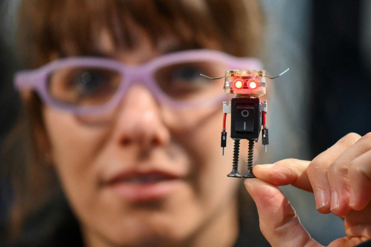 Designer Yacki Lazzari poses holding a figure made with recycled and disused electronic components during the 3rd Federal Cyberciruja Meeting in Buenos Aires. — AFP