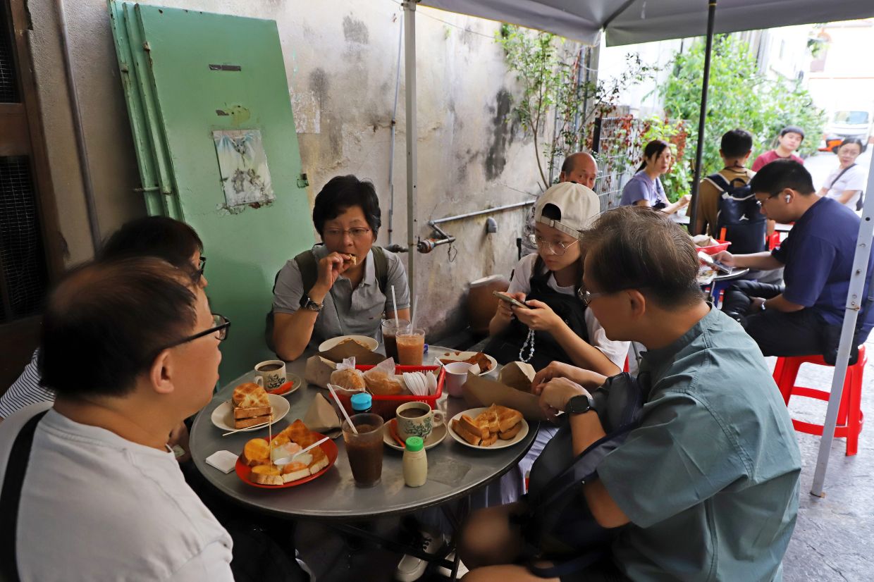 Customers having their breakfast in Toh Soon Cafe is located at a back lane along Campbell Street in Penang. — LIM BENG TATT/The Star