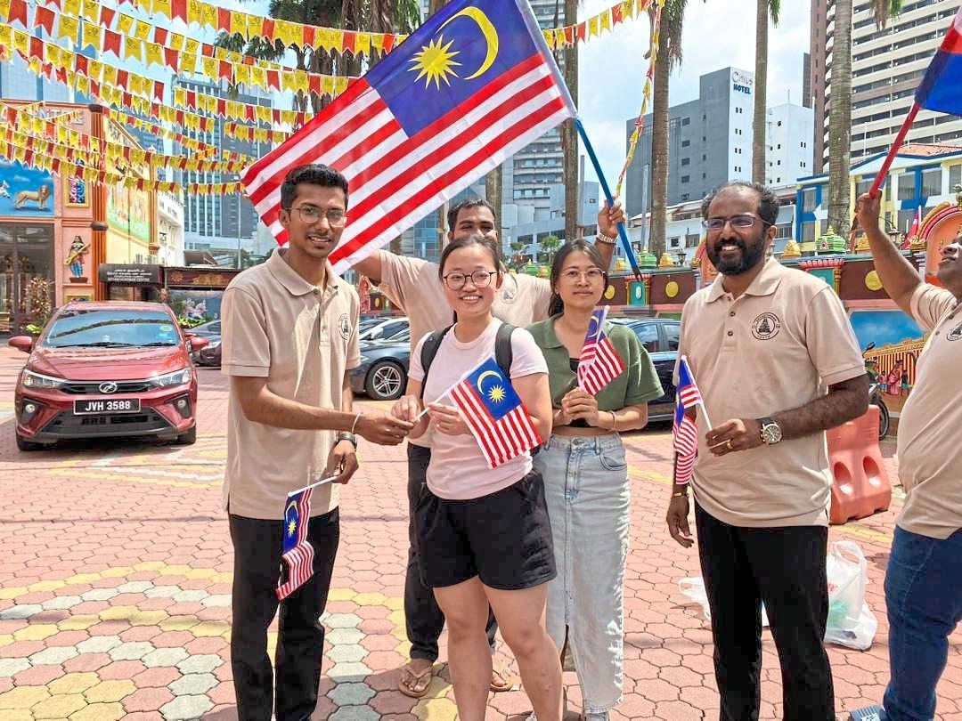 Vinodtheran (right) and his team members handing out flags in Johor Baru.