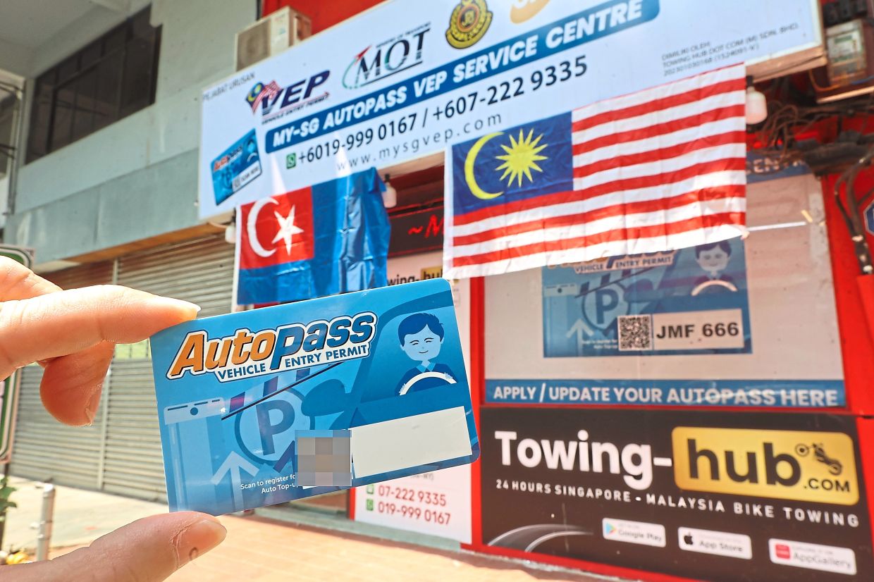A motorist holding a Singapore Vehicle Entry Permit (VEP) in front of a VEP-processing office in Johor Baru. — THOMAS YONG/The Star