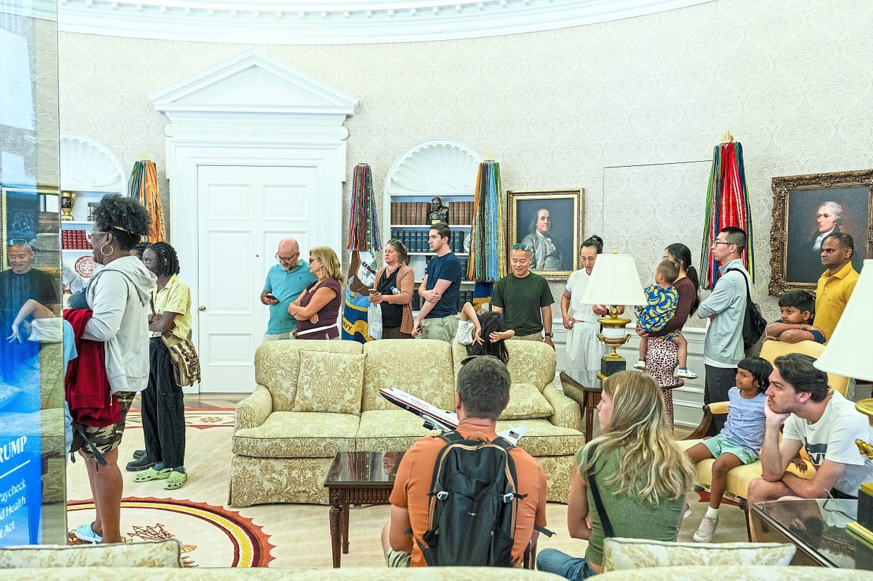 Visitors inside the Oval Office replica at the White House Historical Association.