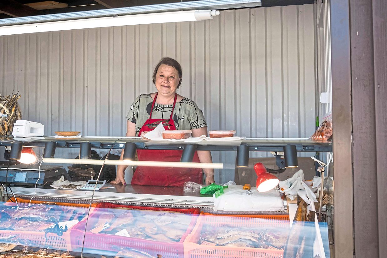 A fish vendor posing inside her market stall in Ragaciems, Latvia. — AFP