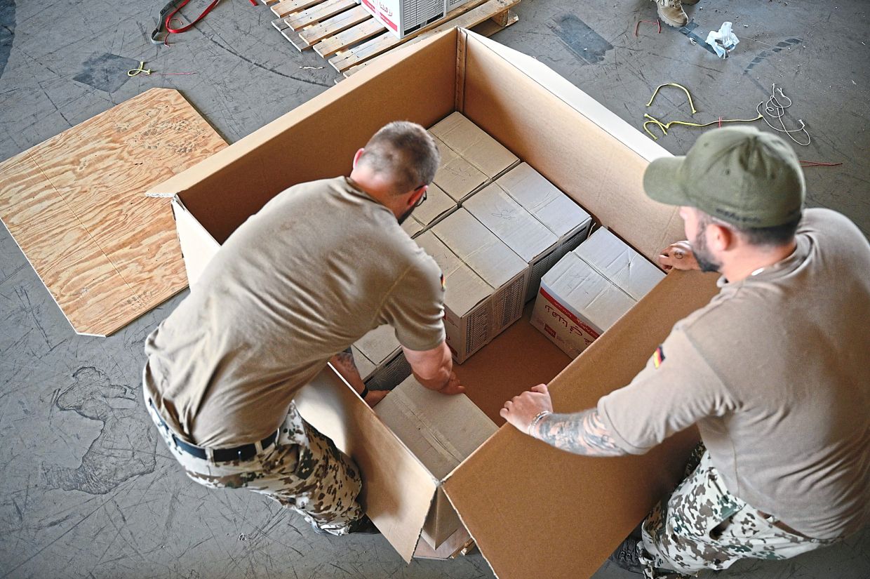 Humanitarian aid supplies being packed on pallets by the German Armed Forces at King Abdullah II Air Base.