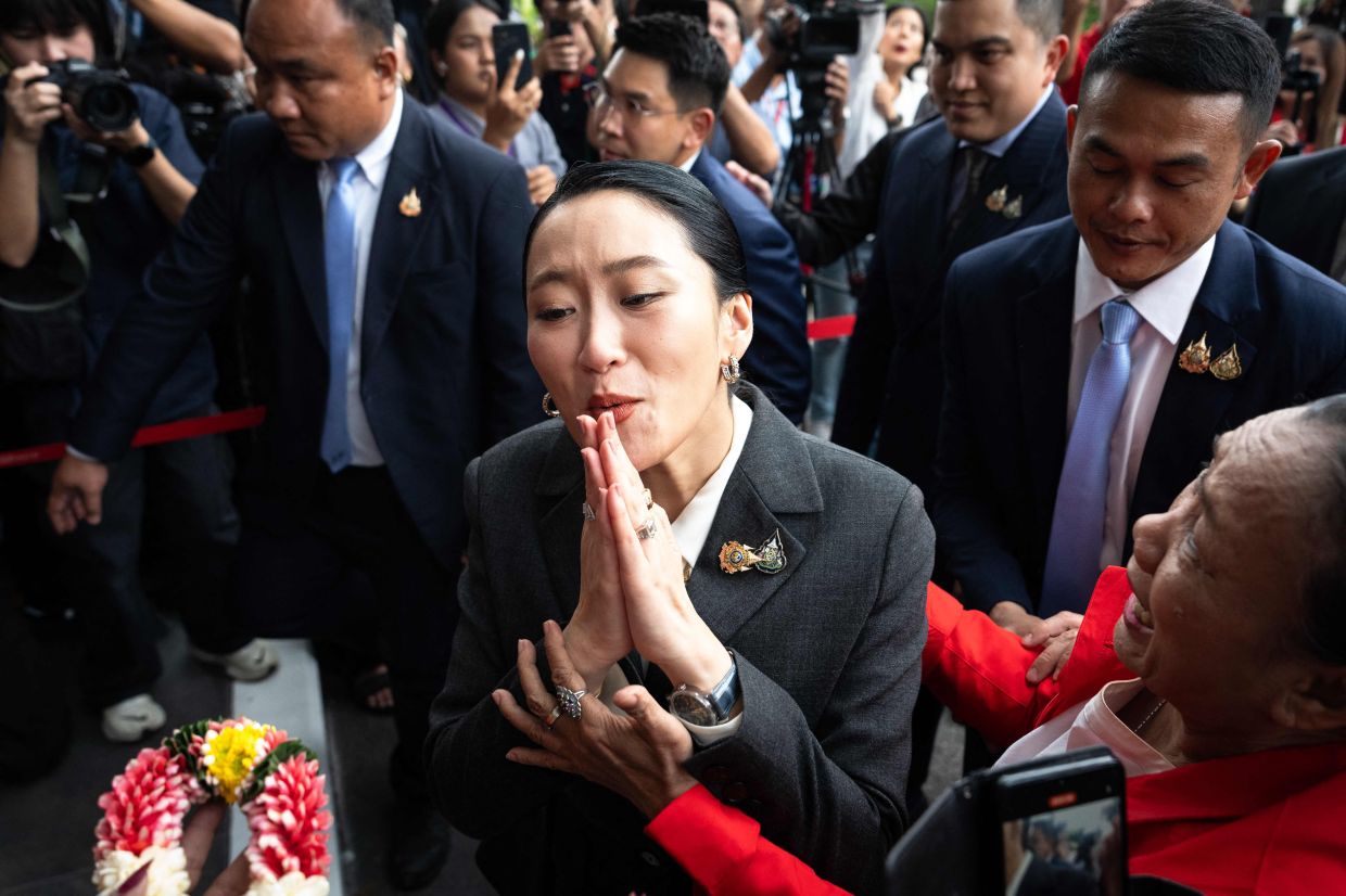 Thailand's sacked prime minister Paetongtarn Shinawatra (C) greets supporters as she arrives at the Pheu Thai Party headquarters after her dismissal by the Constitutional Court in Bangkok on August 29, 2025. Thailand's Constitutional Court sacked Prime Minister Paetongtarn Shinawatra and her cabinet on Friday, August 29, over her handling of the country's border row with Cambodia, throwing the kingdom into political turmoil. -- Photo by Chanakarn Laosarakham / AFP