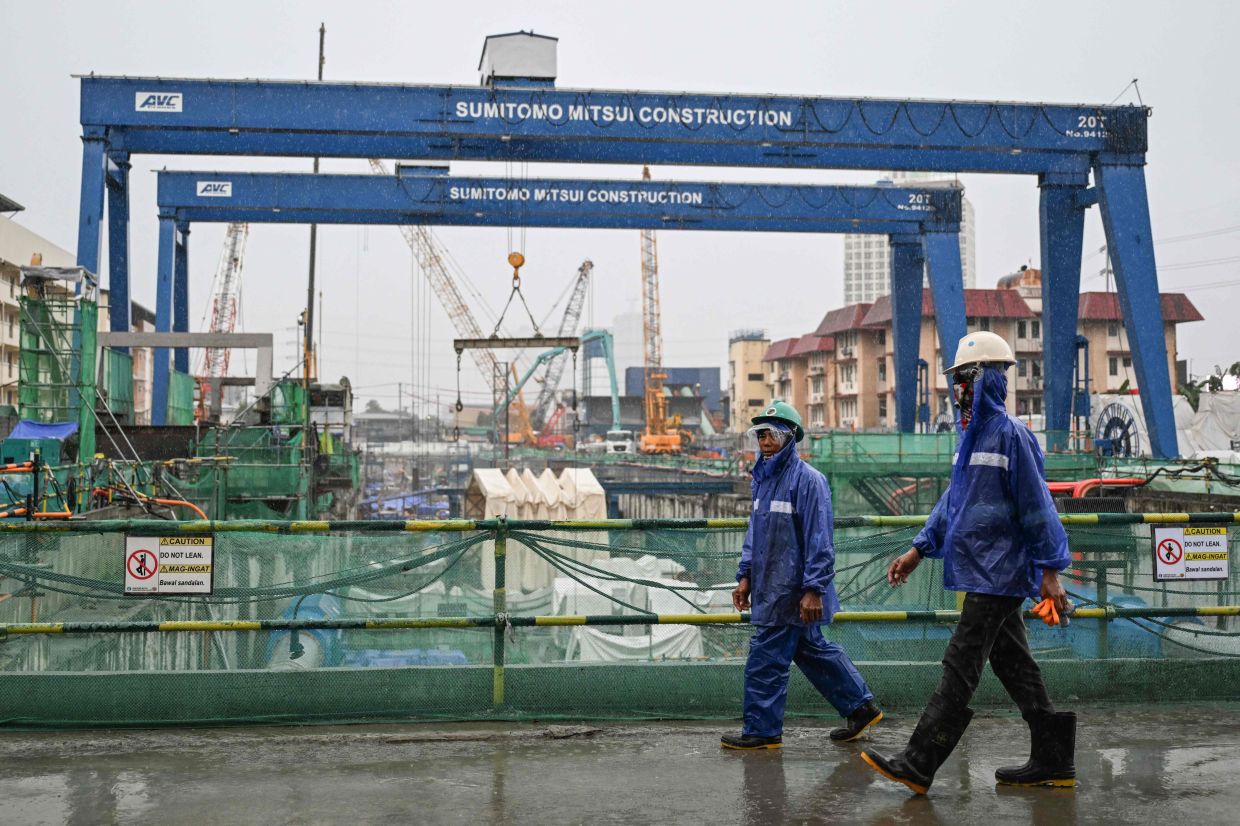 Workers walk around the construction site of the Metro Manila Subway Project (MMSP) during an inspection in Quezon City, Metro Manila. -- Photo by Jam STA ROSA / AFP