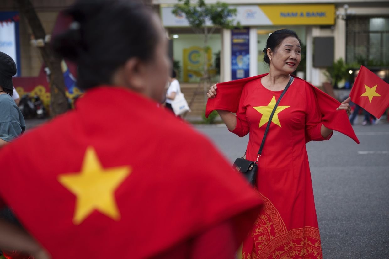 Women wear Vietnam's national flag as the nation celebrating Vietnam's 80th National Day in Hanoi, Friday, Aug. 29, 2025. -- AP Photo/Vincent Thian
