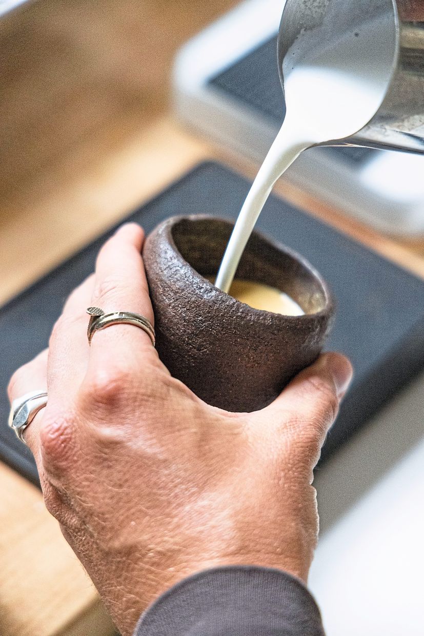 Kinori holds a cup by Los Angeles-based maker Jordan Vouga, in his San Francisco shop.