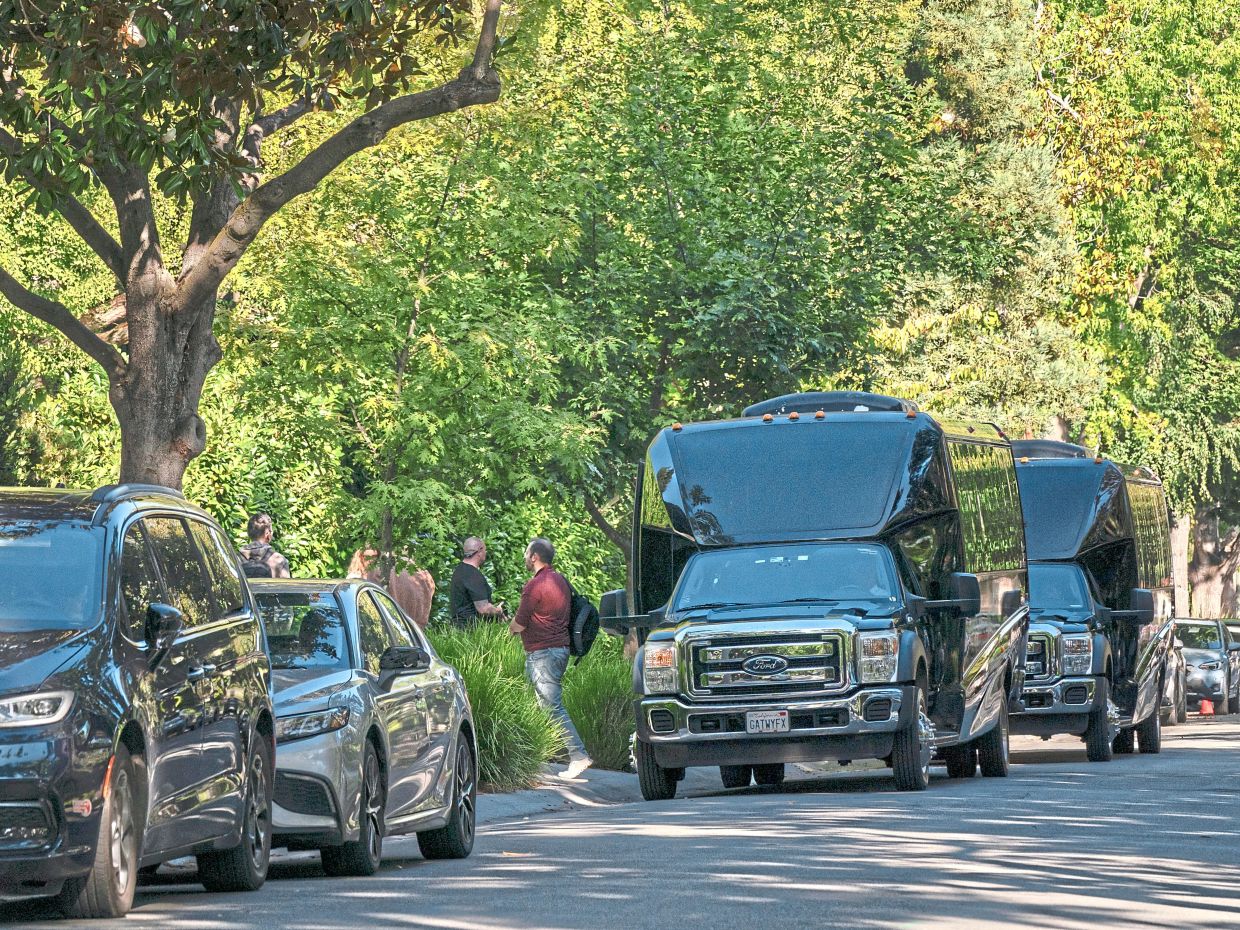 Passenger vans drop off people for a private event at a house owned by Zuckerberg.
