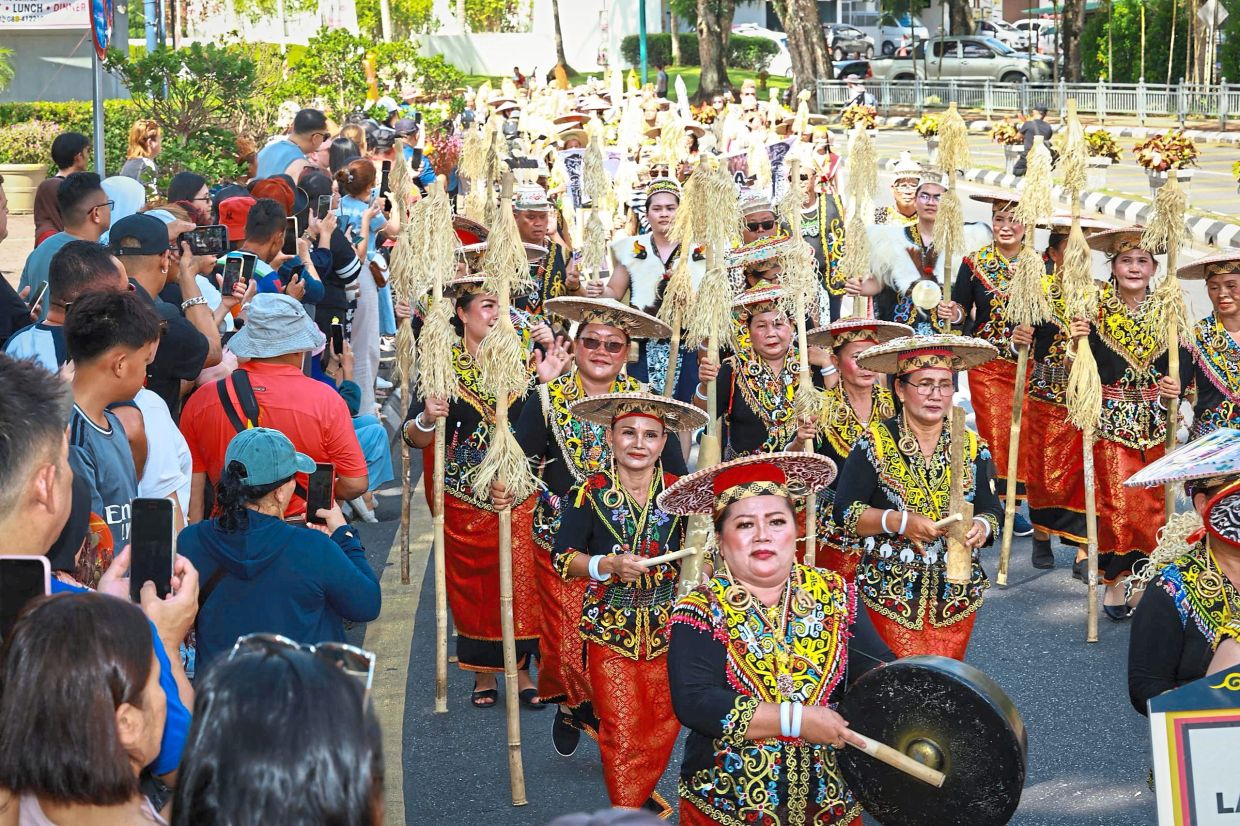 An Orang Ulu contingent walking past a crowd of onlookers during the Niti Daun parade.