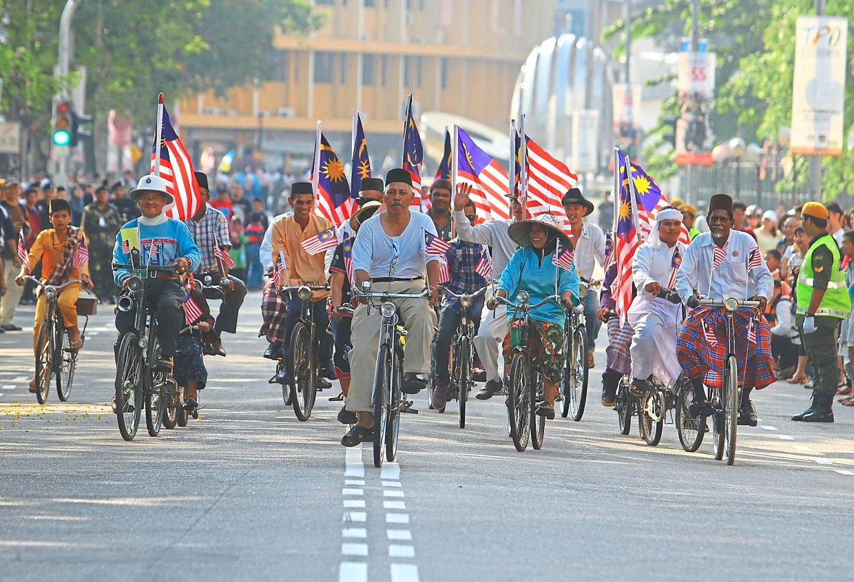 A ride down memory lane as cyclists dressed in vintage clothing joined the 55th Merdeka parade at the Esplanade in George Town, Penang. — MUHAMAD SHAHRIL ROSLI/The Star
