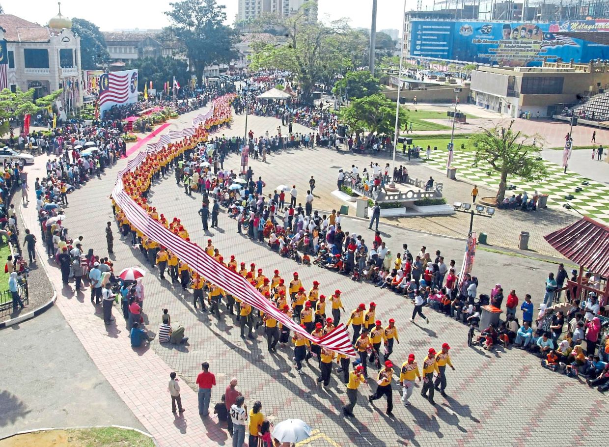 A striking display of patriotism as marchers carried a long stretch of the Jalur Gemilang during the Malacca-level National Day parade at Dataran Pahlawan. — A. MALEX YAHAYA/The Star