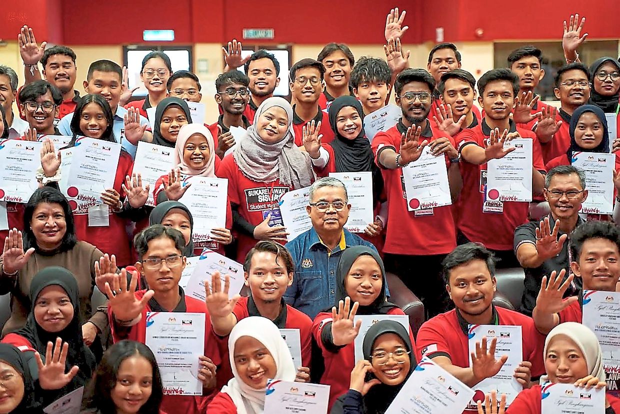 Aaron (centre) with student volunteers proudly displaying their certificates at a Yayasan Sukarelawan Siswa event, an initiative under National Unity Ministry that promotes volunteerism as a means of strengthening national integration and unity.