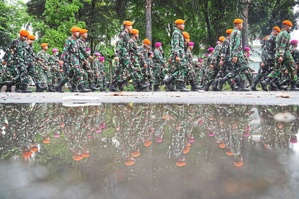 Military personnel being deployed to secure a street following violent protests. — AFP/AP/Reuters