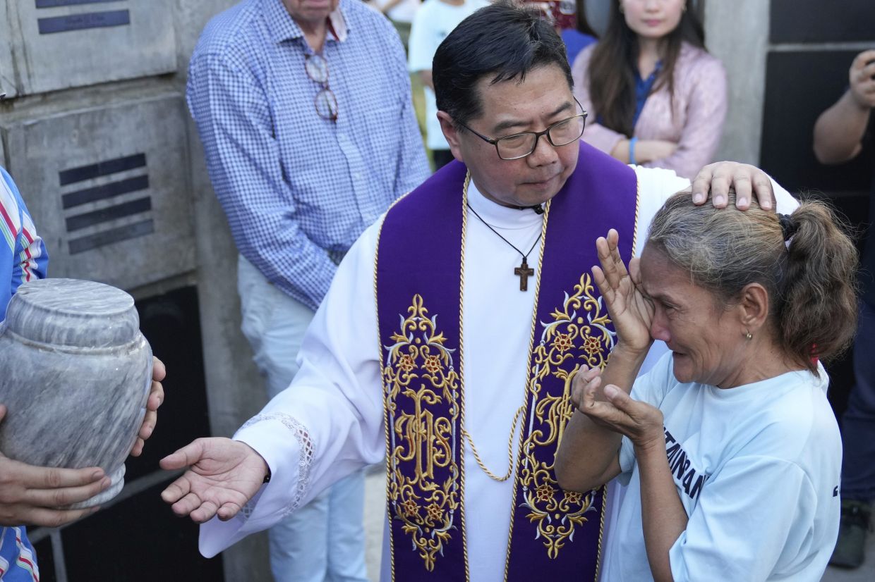 Filipino Catholic priest Flavie Villanueva (left) consoles a devotee during a meeting. The priest is the recipient of the prestigious Ramon Magsaysay Award Foundation awards, the Asian version of the Nobel Prize. - AP Photo/Aaron Favila
