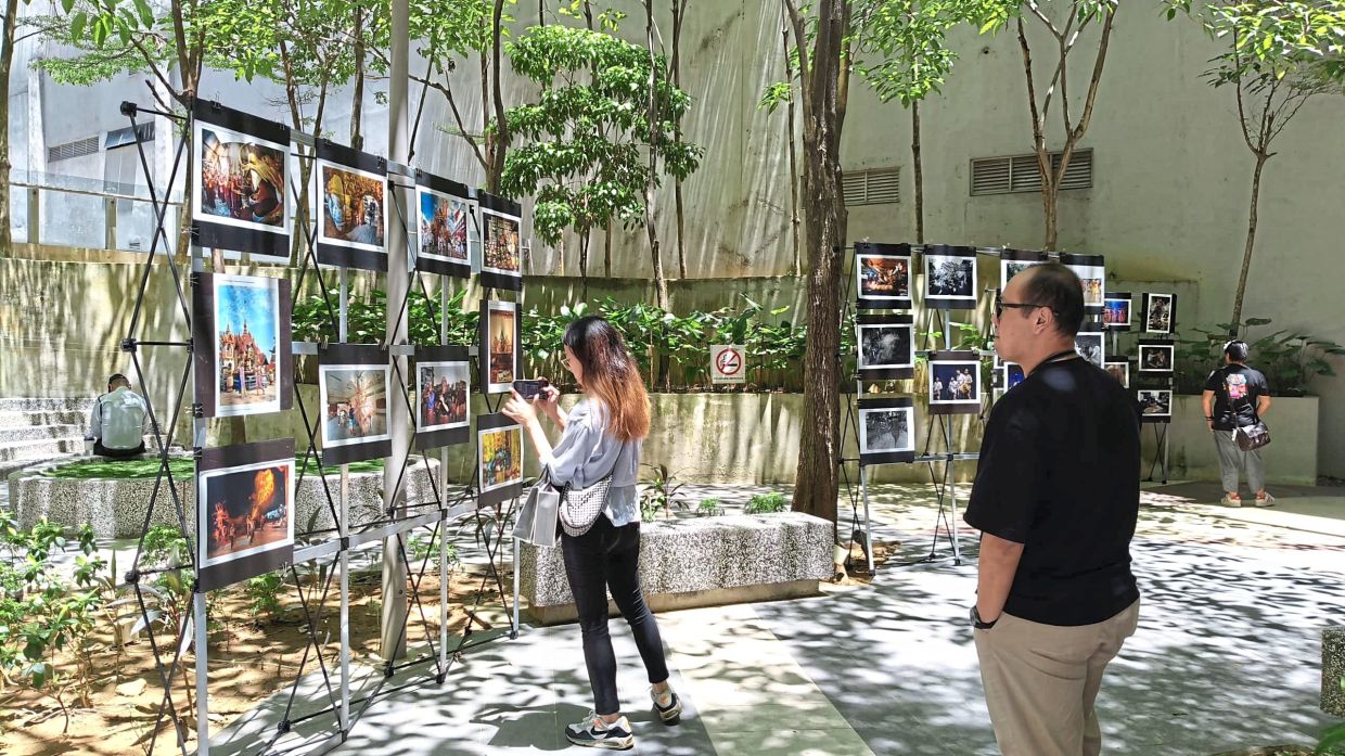 A visitor taking photos of the images on display.