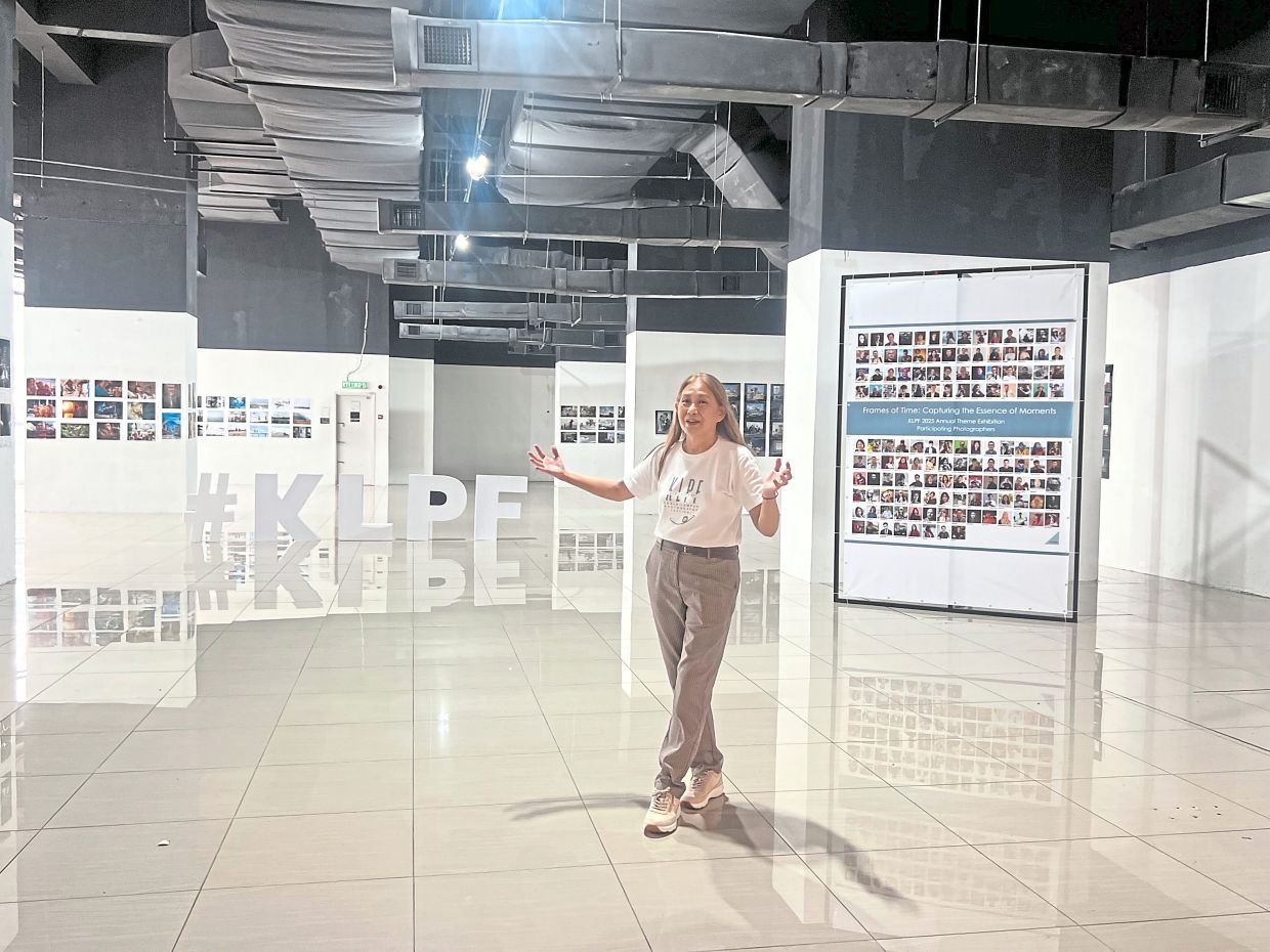 Chan in front of the exhibition pictures.