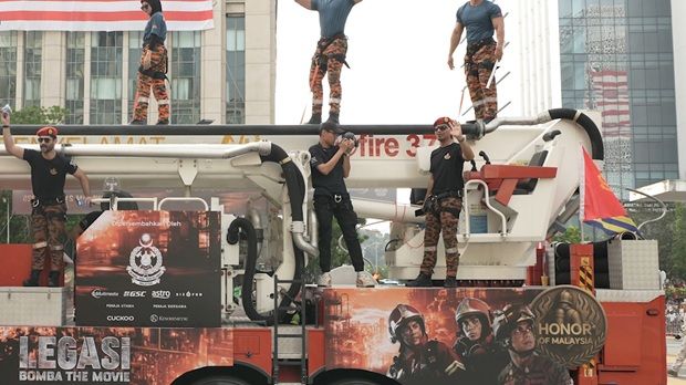 “Legasi: Bomba The Movie” actors on a Merdeka Parade firetruck wrapped in the movie’s promotional material.