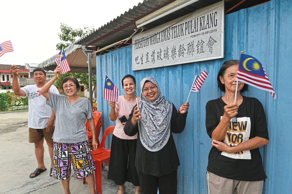 Local residents waving the Jalur Gemilang and sing Negaraku.