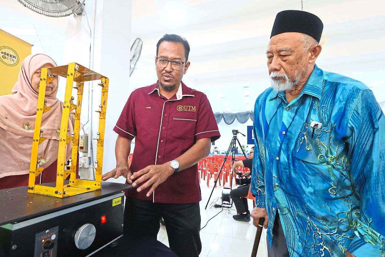 Under the surface: A welcome sign as people drive into Segamat. (Inset) Mohd Zamri (centre) showing how an earthquake impacts a building during an earthquake disaster risk management programme. — THOMAS YONG/The Star