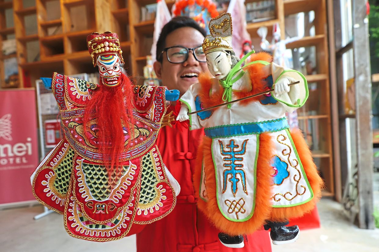 Andhika showing puppets typically used in Indonesia (left) and Taiwan.