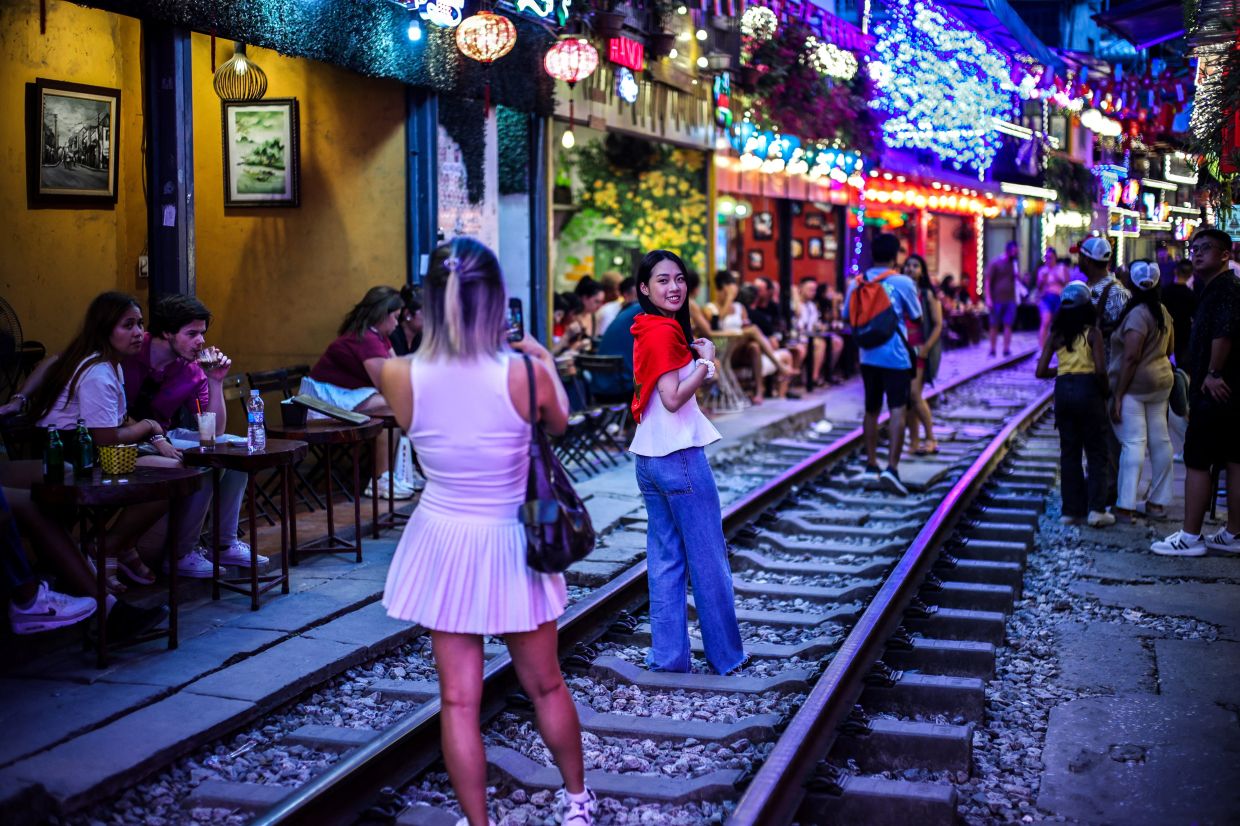 Tourists visit Hanoi Train Street, one of the famous tourist destinations in Hanoi, Vietnam. -- Photo: REUTERS/Athit Perawongmetha