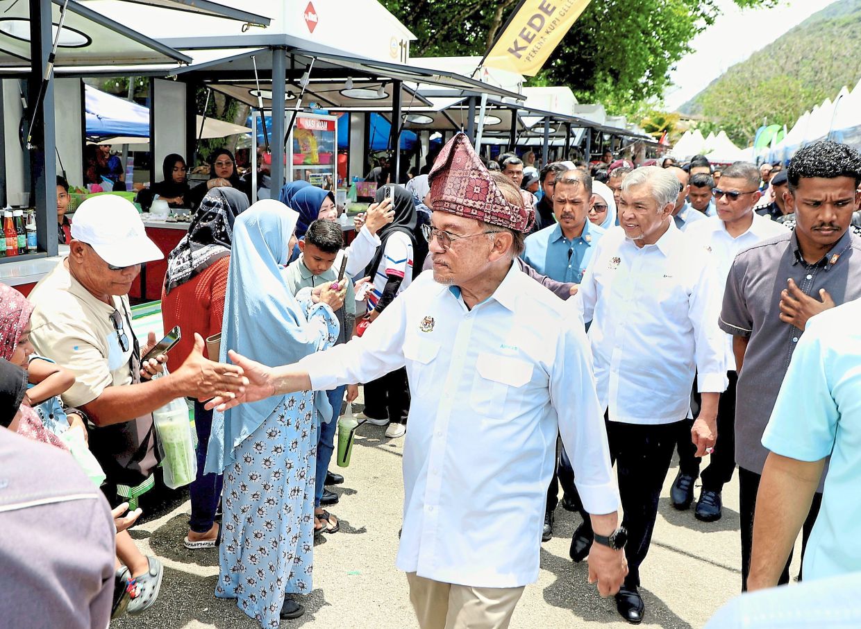 Meeting the people: Anwar attending the state-level PMR closing ceremony in Baling, Kedah. Accompanying him are Ahmad Zahid and Saifuddin Nasution. — LIM BENG TATT/The Star