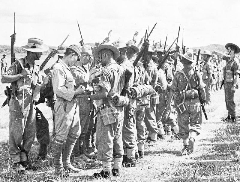 The Japanese army undergoing checks by the 25th Indian Division following their surrender in Kuala Lumpur. — UK National Archives