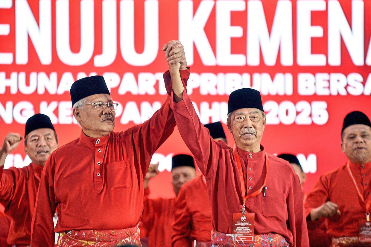 Restated friendship: Muhyiddin (right) and Hamzah holding hands at the Bersatu AGM in Shah Alam. — AZLINA ABDULLAH/The Star