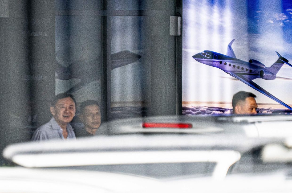 Thailand's former Prime Minister Thaksin Shinawatra (left) leaves the private jet terminal at Bangkok's Don Mueang International Airport, after he landed back in Thailand on Monday, September 8, 2025. Thaksin jetted away last week as his dynasty's party was ousted from office, fuelling speculation he had absconded from a Supreme Court inquiry probing whether he properly served a prison sentence. -- Photo by Arnun Chonmahatrakool / THAI NEWS PIX / AFP
