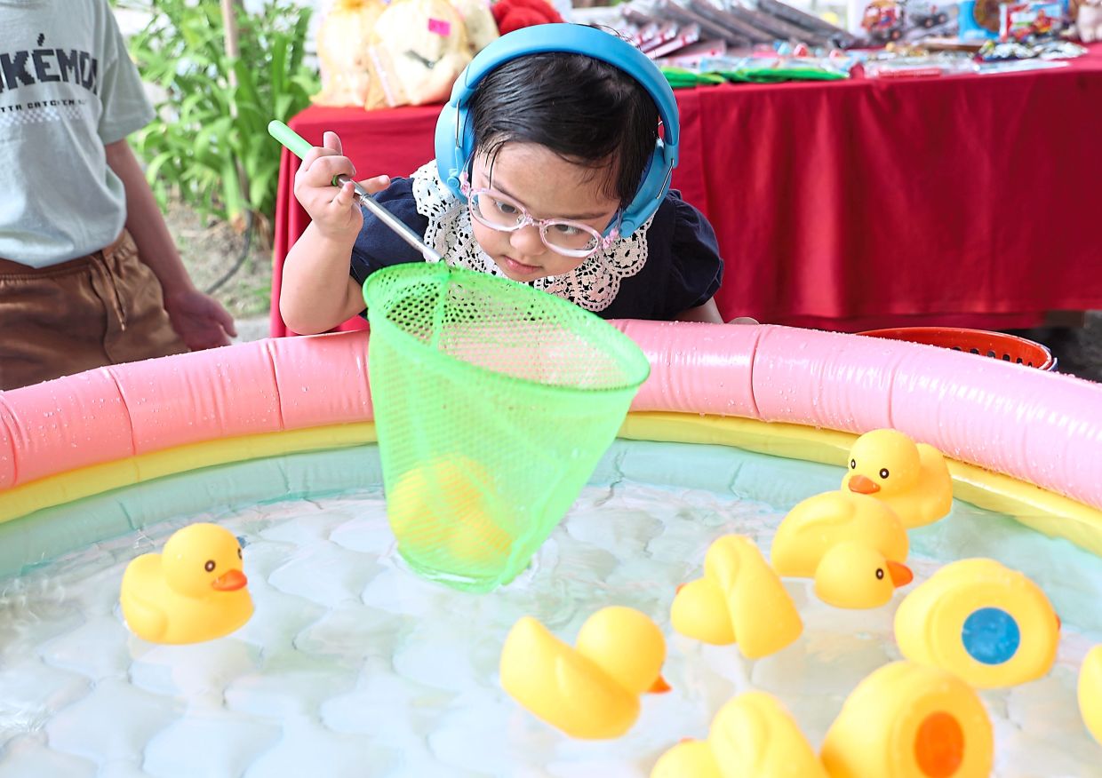 Rose Zaimi’s daughter playing a game to net ducks. — Photos: ART CHEN/The Star