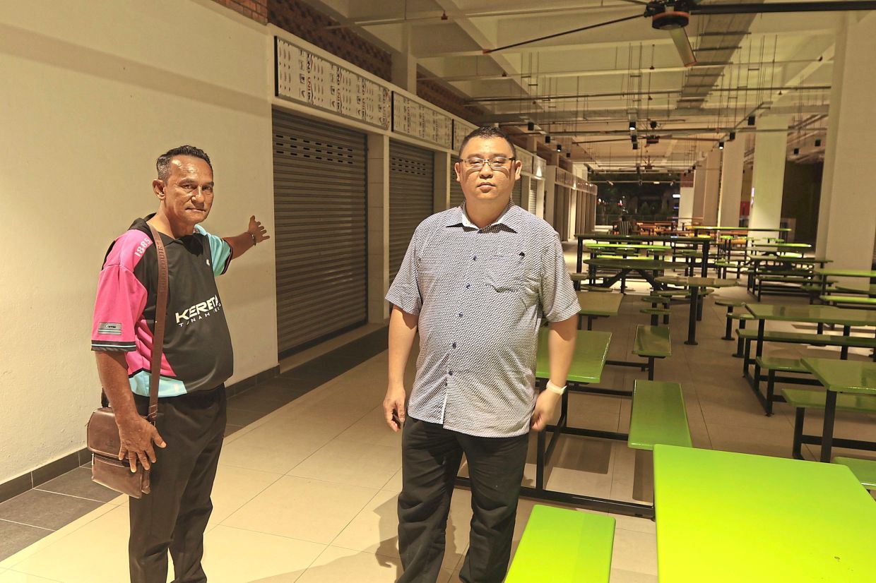 Mohd Ramdzan (left) and Lai showing the empty lots that will soon be occupied by food traders.