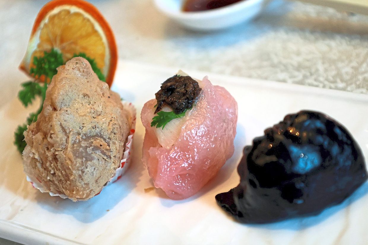 (From left) Taro chicken croquette, scallop and prawn dumpling garnished with truffle and crystal charcoal skin prawn dumpling with speckles of gold dust.