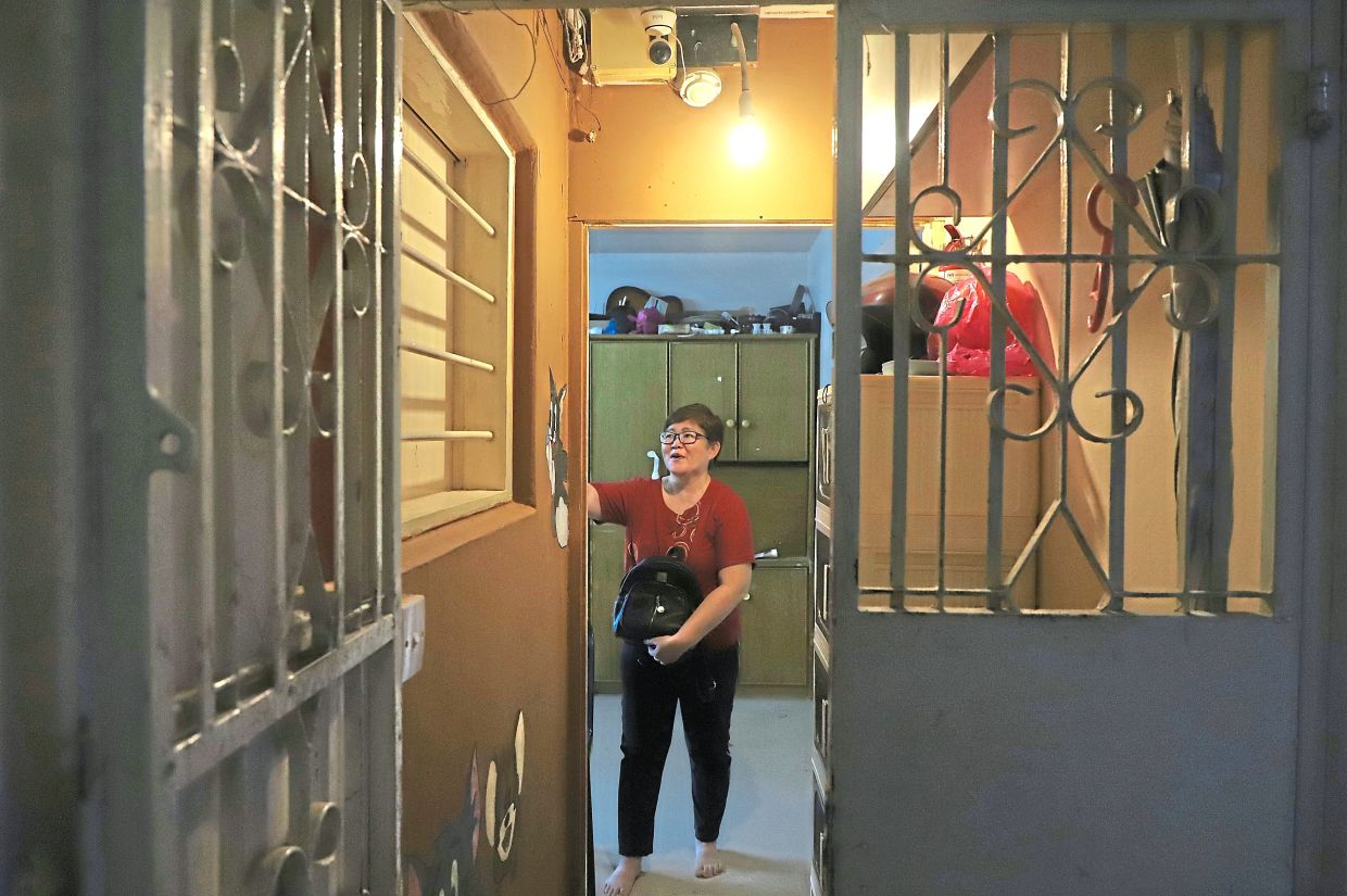 Resident Cheang Wai Long, 55, at the entrance of her Rifle Range home in Air Itam, Penang.