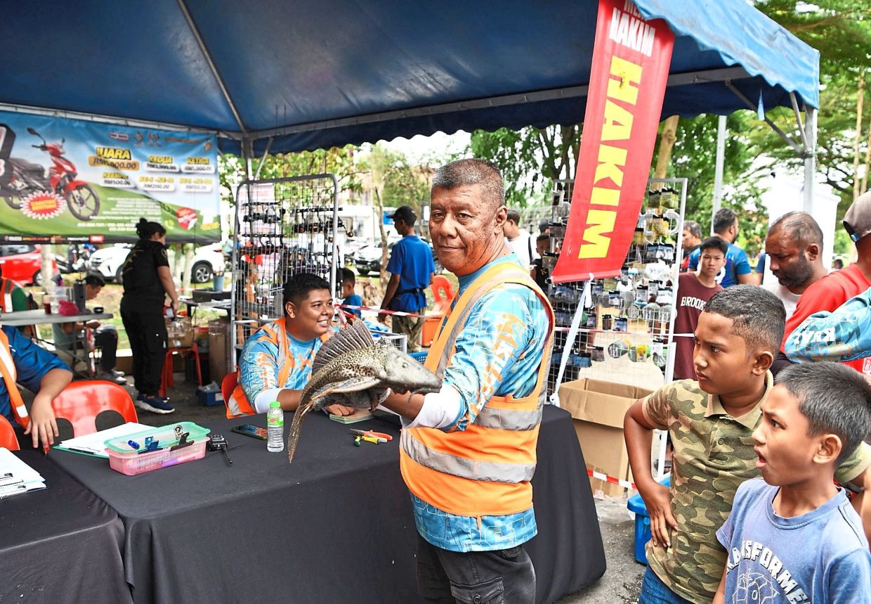 Two boys awed by a catch brought in for judging.