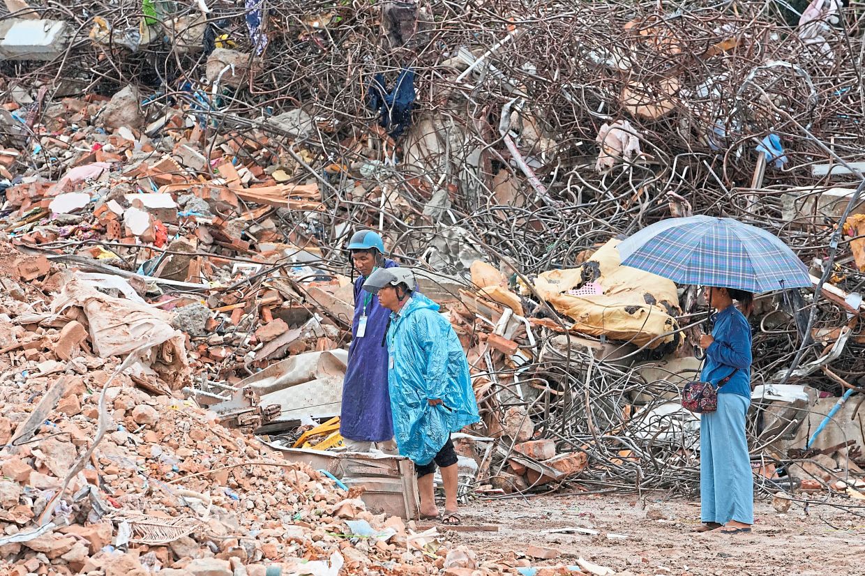 Thae Mama Swe standing at the site of Sky Villa, a 10-storey condo that collapsed during the March 28 earthquake. — AP