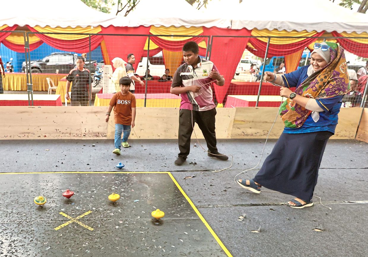Children trying their hand at gasing pangkah at PJ Bergasing 2025.