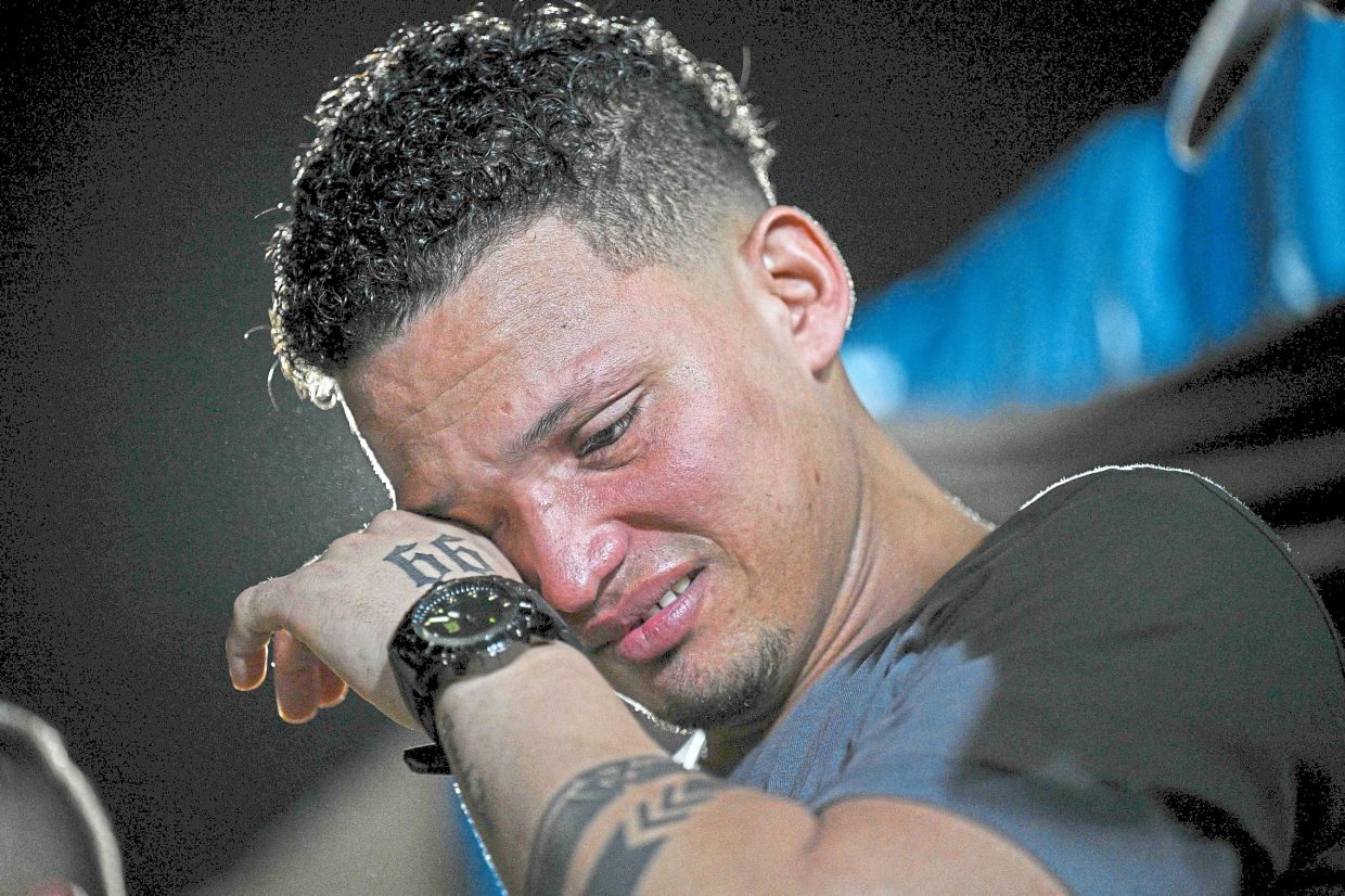 Yamarte crying during a Christian evangelical service in Los Pescadores neighbourhood in Maracaibo. — AFP