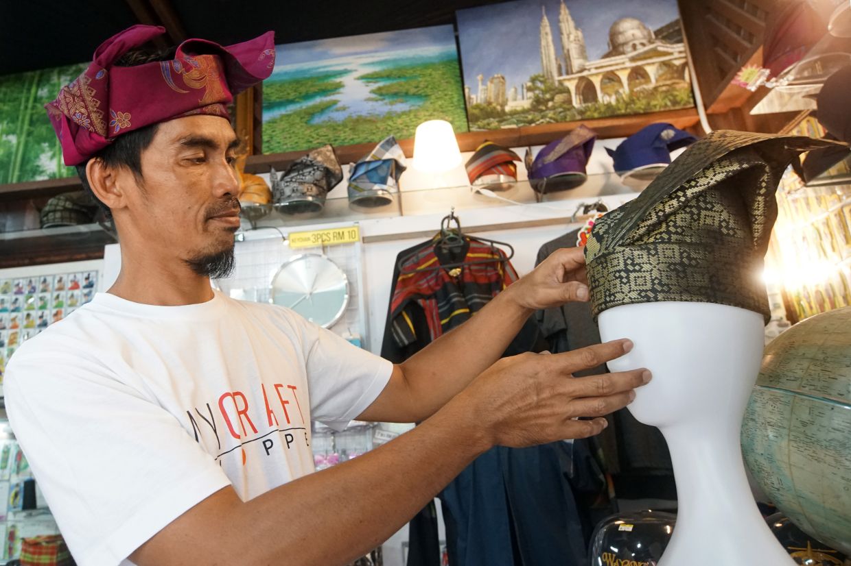 Mohd Iskandar Abd Rahim, 45, adjusting a traditional tanjak at his shop in Johor Baru. Photo: The Star/Thomas Yong