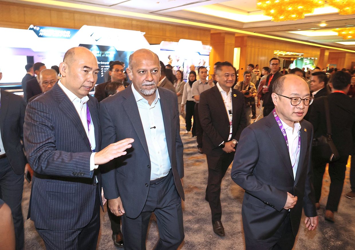 Unlocking growth: Gobind (right) and Ng visiting booths at the ACCCIM Asean AI Business Summit. — ART CHEN/The Star